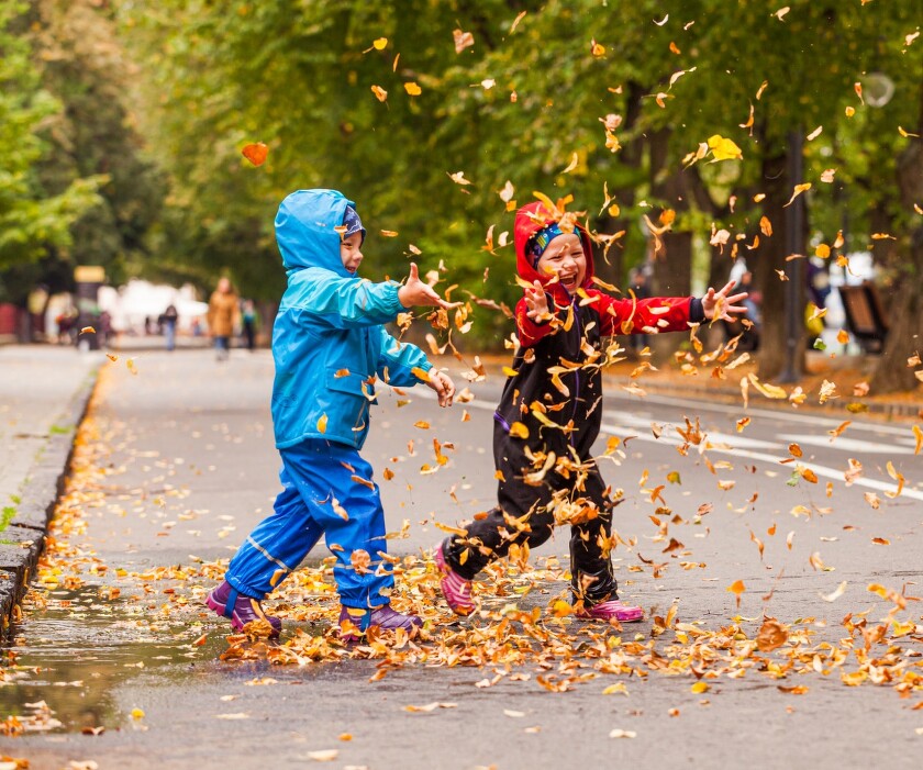 smiling-little-children-are-playing-with-fallen-leaves-during-autumn-walk-boy-girl-warm-clothes-throw-up-leaves